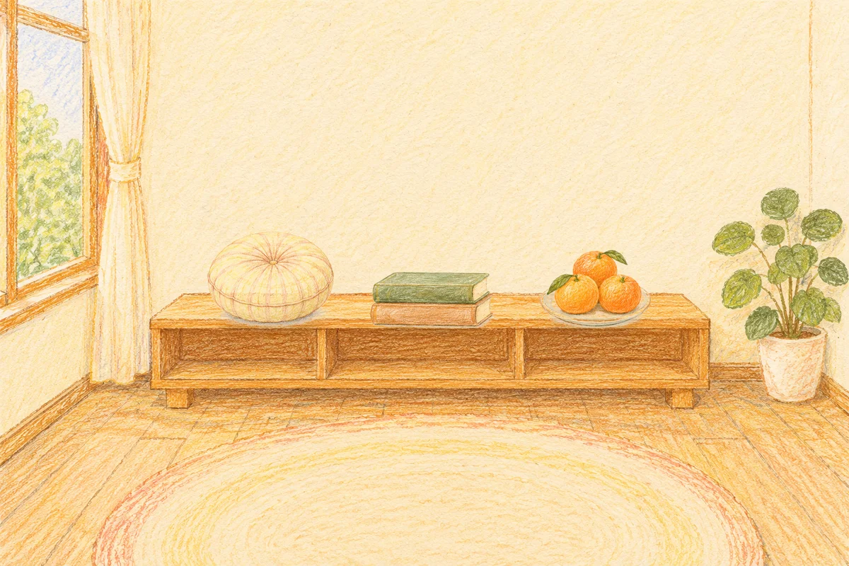 오산 여성전용 방문 마사지 안내 그림, 낮의 창가 낮은 선반 위에 놓인 둥근 쿠션, 책 두 권, 귤이 담긴 접시