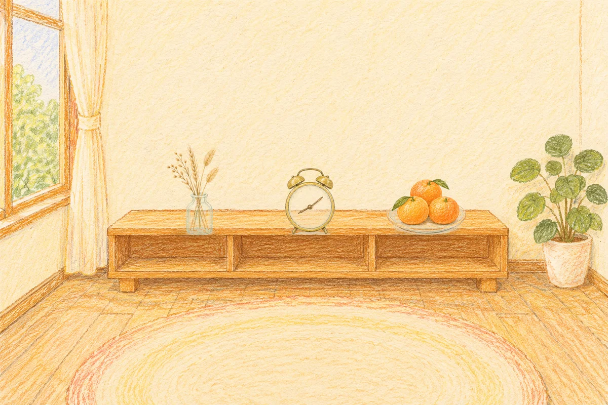 구리 여성전용 후기 마사지 안내 그림, 낮의 창가 낮은 선반 위에 놓인 마른 풀을 꽂은 항아리, 둥근 알람시계, 귤이 담긴 접시