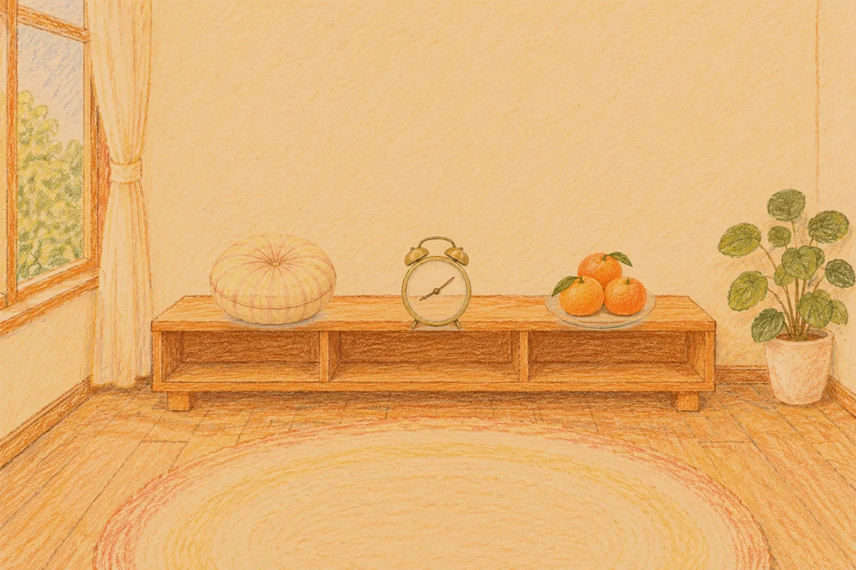 의왕 여성전용 바디 경락 안내 그림, 저녁의 창가 낮은 선반 위에 놓인 둥근 쿠션, 둥근 알람시계, 귤이 담긴 접시