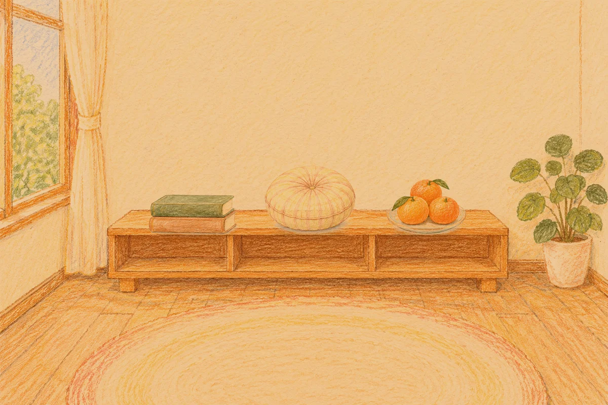 강동 여성전용 얼굴 경락 안내 그림, 저녁의 창가 낮은 선반 위에 놓인 책 두 권, 둥근 쿠션, 귤이 담긴 접시