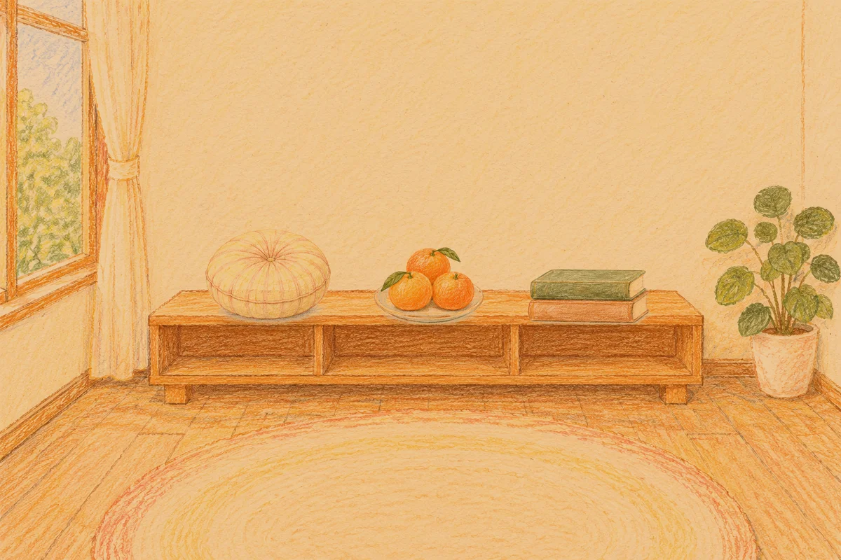 반포동 여성전용 출장 마사지 안내 그림, 저녁의 창가 낮은 선반 위에 놓인 둥근 쿠션, 귤이 담긴 접시, 책 두 권