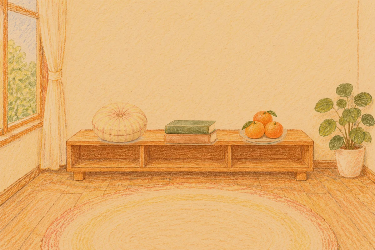 왕십리 여성전용 바디 경락 안내 그림, 저녁의 창가 낮은 선반 위에 놓인 둥근 쿠션, 책 두 권, 귤이 담긴 접시