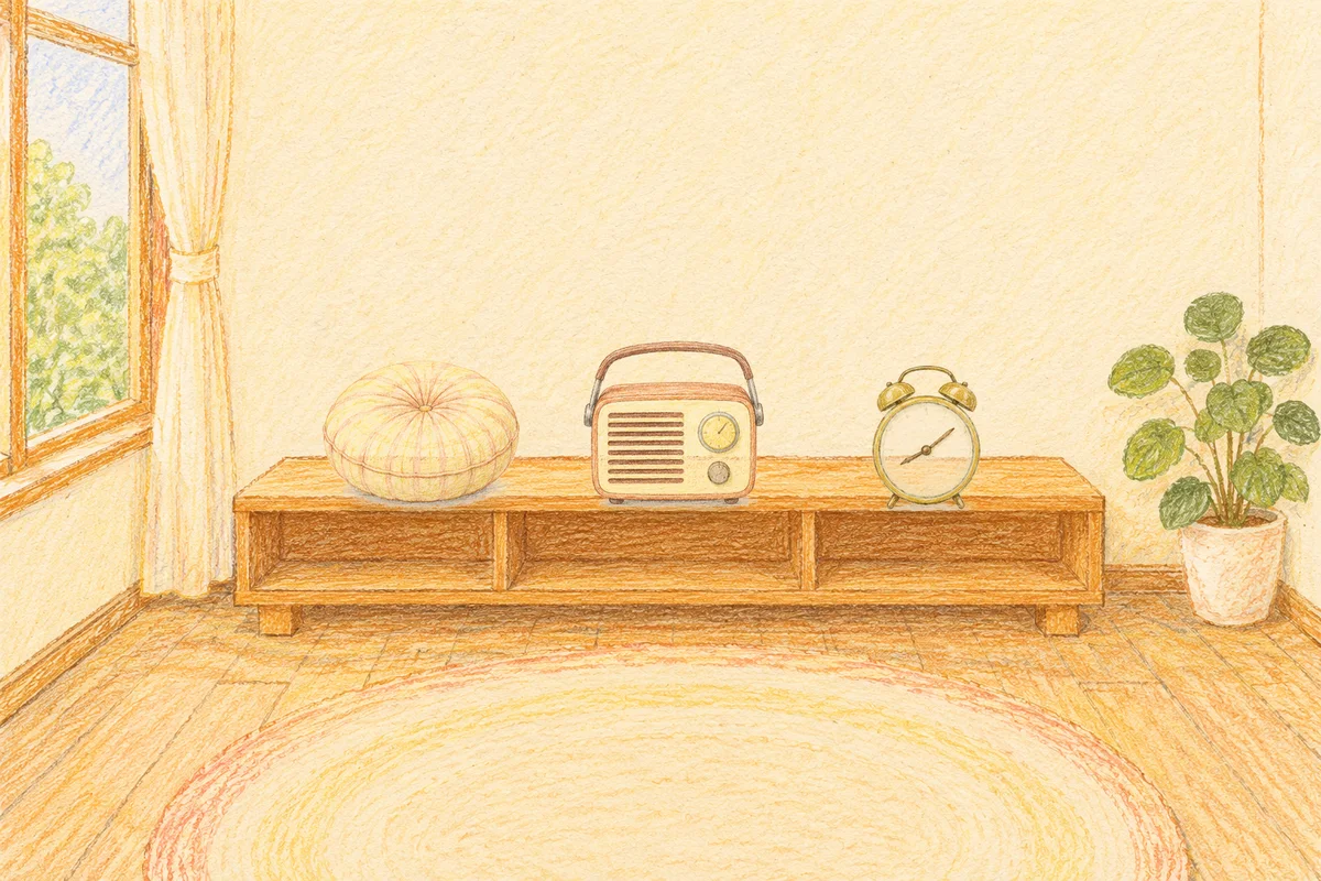 도선동 여성전용 아로마 가격 안내 그림, 낮의 창가 낮은 선반 위에 놓인 둥근 쿠션, 작은 라디오, 둥근 알람시계