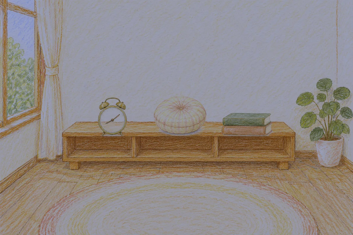 구로디지털단지 여성전용 목 어깨 케어 안내 그림, 밤의 창가 낮은 선반 위에 놓인 둥근 알람시계, 둥근 쿠션, 책 두 권